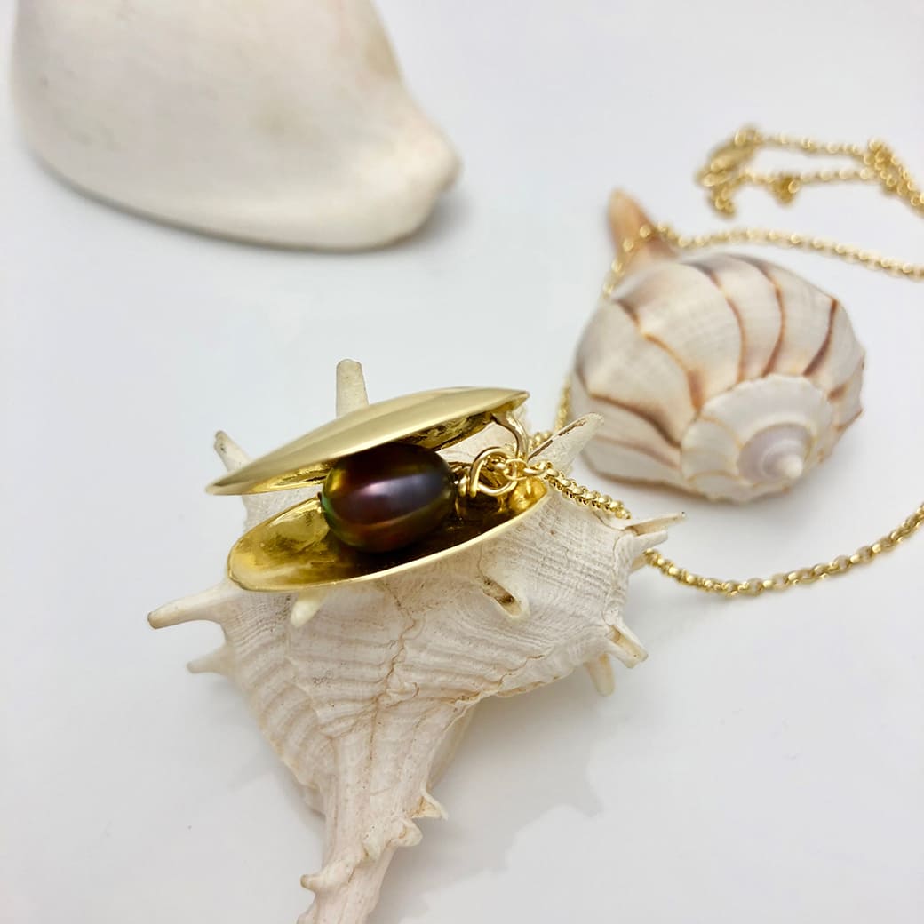 Goldplated Double ClamNecklace displayed on a whelk shell - Charms Collection - Jennifer Kinnear Jewellery